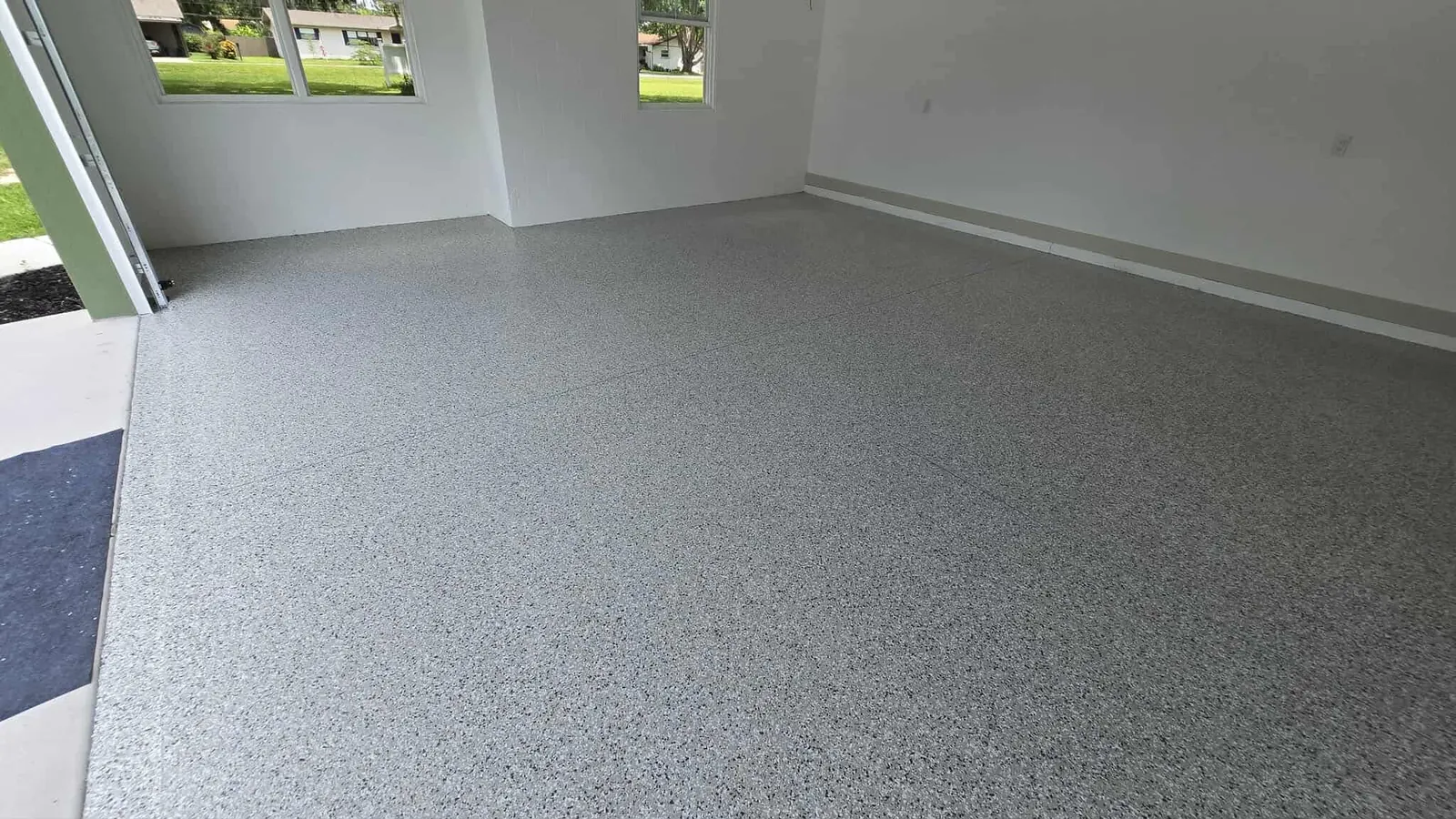 Bright finished room with a gray flake floor
